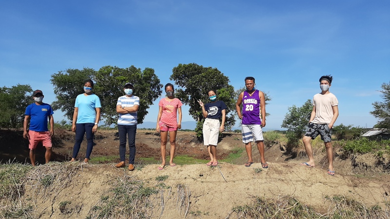 Seven masked people preforming community service. 