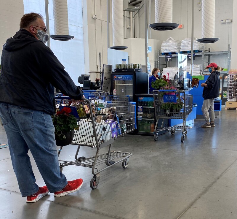 Masked customers and employees at a grocery store. 