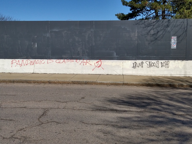 red graffiti stating "pandemic is class war"