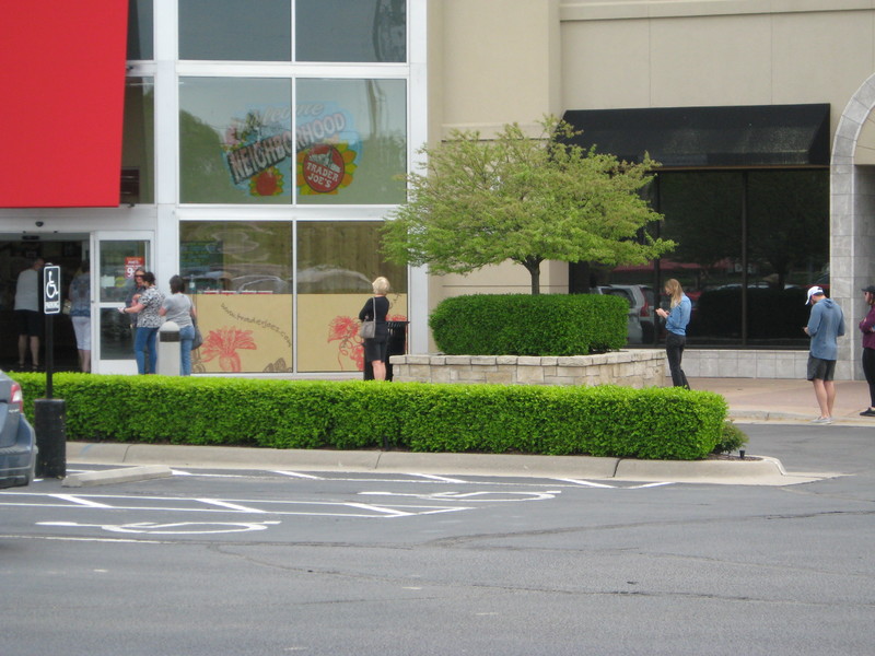 Image of people social distancing outside of a grocery store.