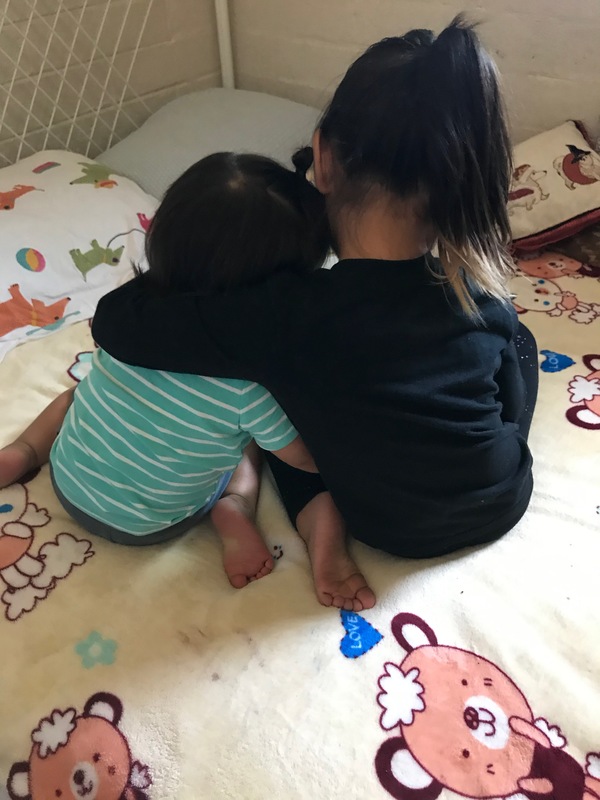 Two children sitting in bed together. 