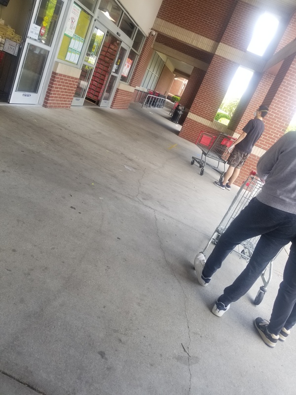 People standing outside a grocery store. 