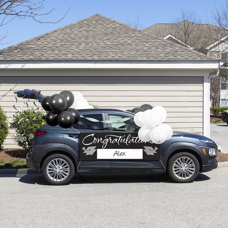 This is a picture of a car covered in balloons, with "Congratulations Alex" written on the side. 