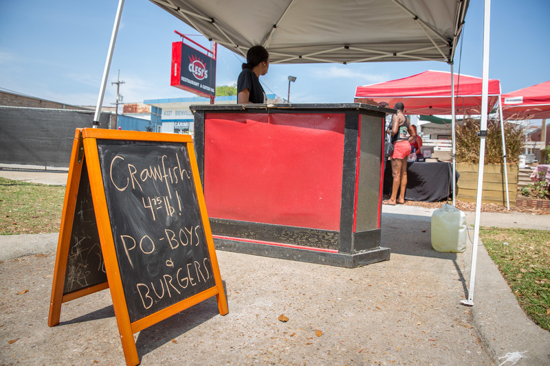 Food tent with a sign that says "Crawfish 4.75lb! Po Boys and burgers."