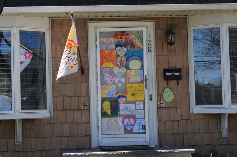 Residential house with multiple rainbows that cover the entire front screen door. 