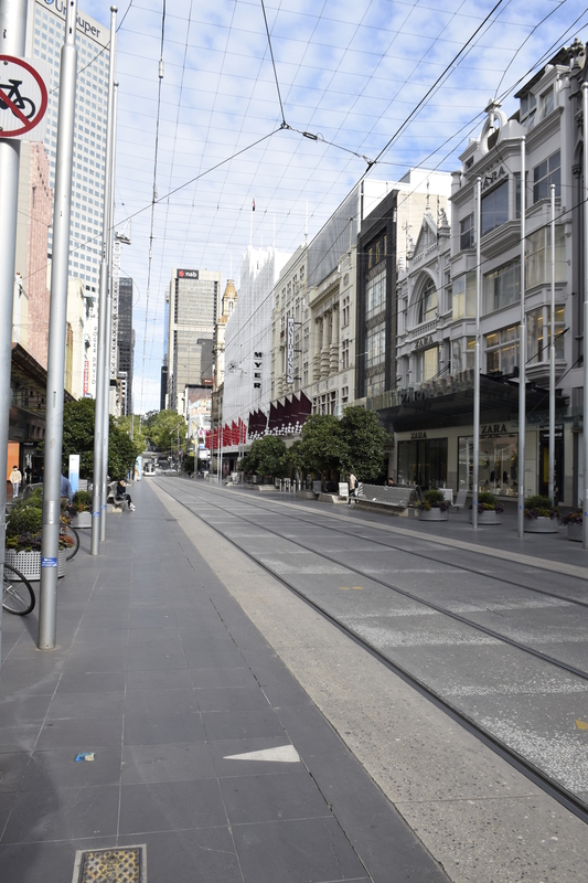 An empty street with buildings on both sides. 