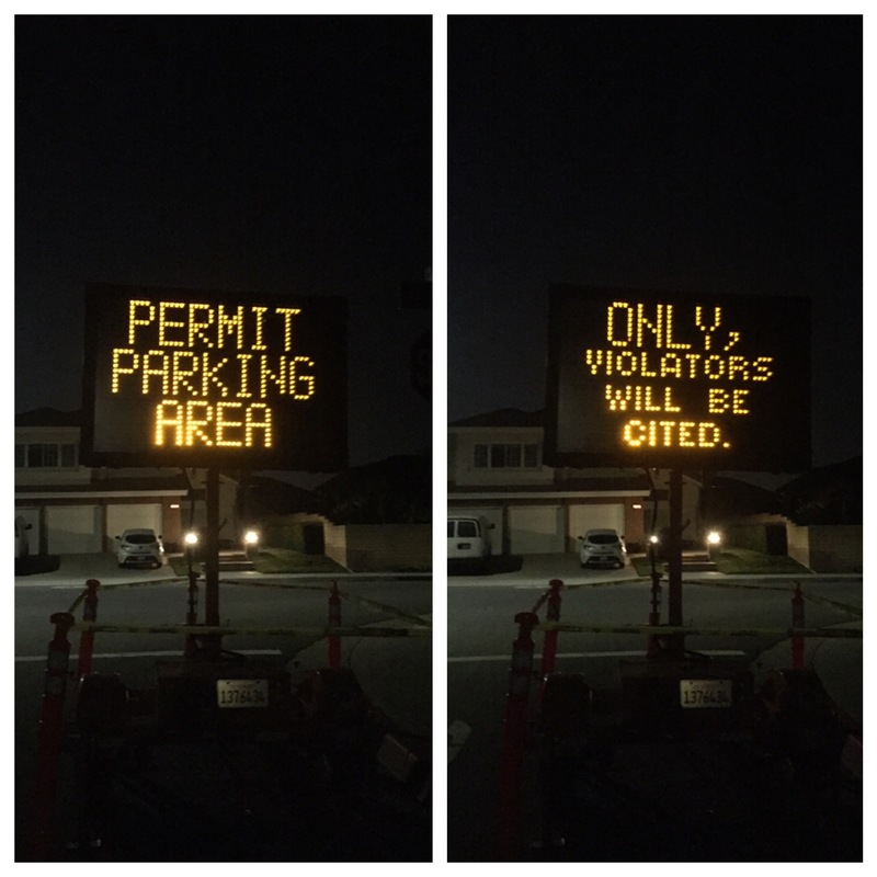 A permit parking warning sign on a road.