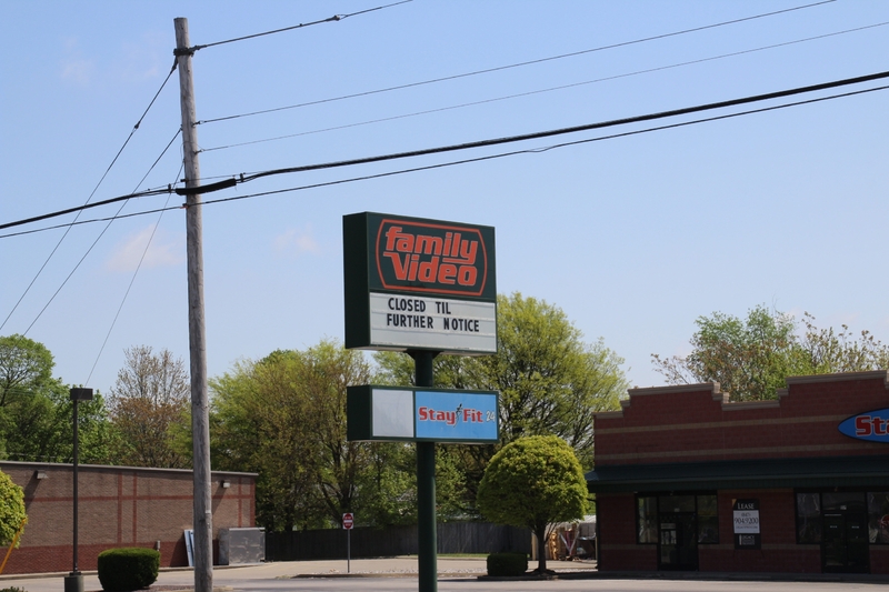 A sign outside of a family video store reading "Closed Til Further Notice"