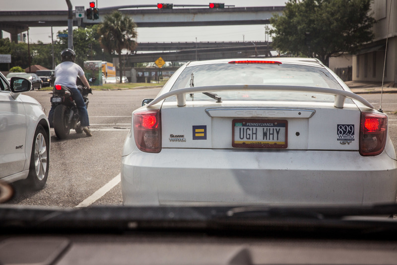 A white Toyota Celica with a license plate that says "Ugh Why" on it. 