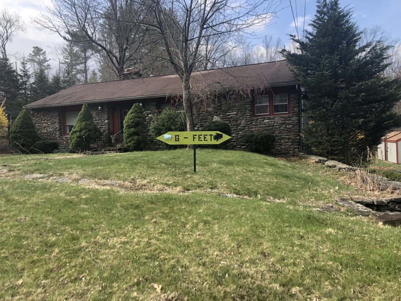 A social distancing sign that is in front of a house. 