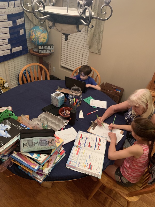 Two children doing homework with an older woman. 