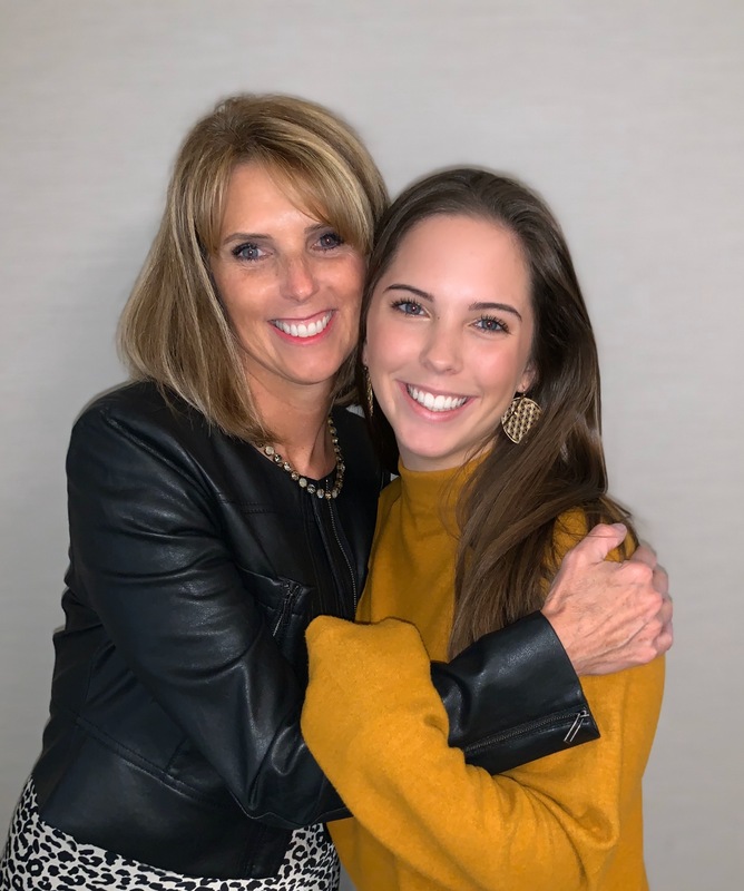 Mother and college student daughter hugging.