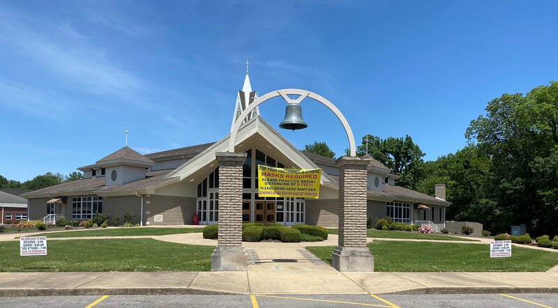 A church exterior with multiple signs. 