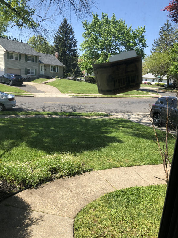 View out glass front door with a five dollar bill taped on the outside. 