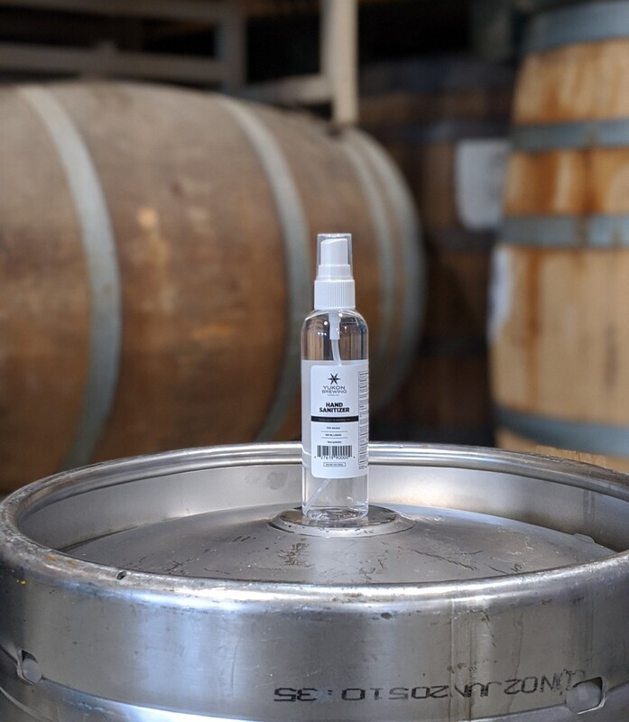 This is a picture of a small bottle of hand sanitizer resting on top of a beer keg. 