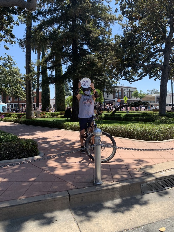 A person on a bike holding up a white plate. 