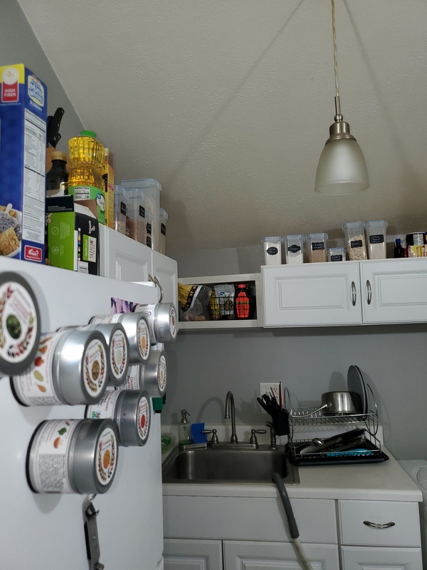 Kitchen cabinets with organized bins above.