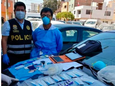 A COVID-19 rapid test set up on a car with a police officer and another person present. 