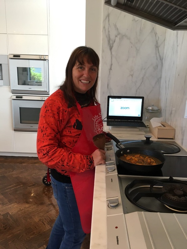 A woman cooking with a Zoom call open to the side.