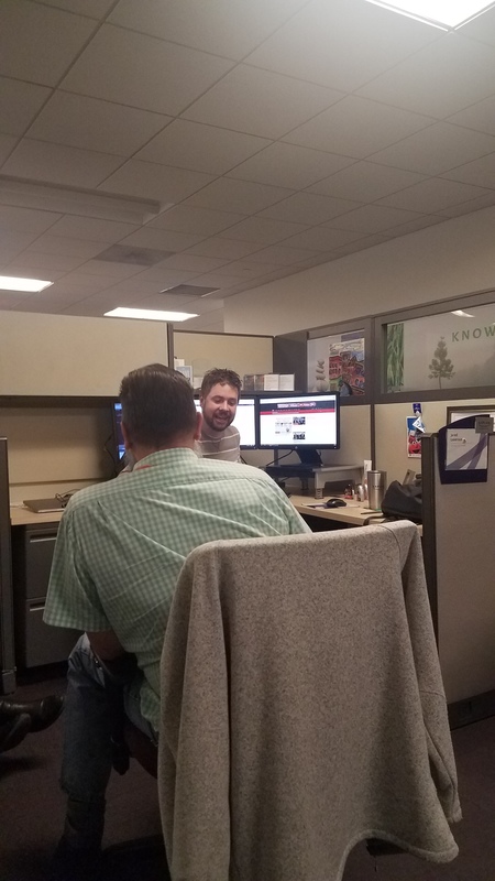 two office workers talking in their cubical 