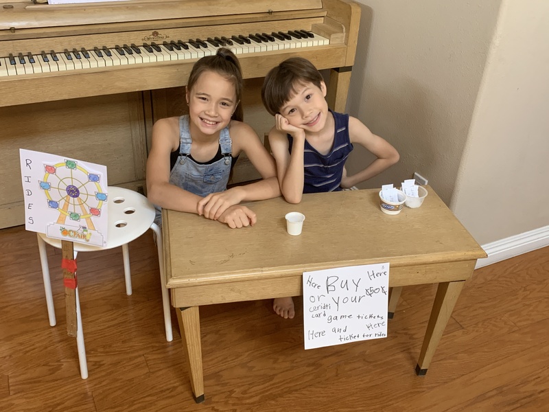 Two children mimicking a county fair at home. 