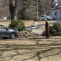 A person standing next to a car. 