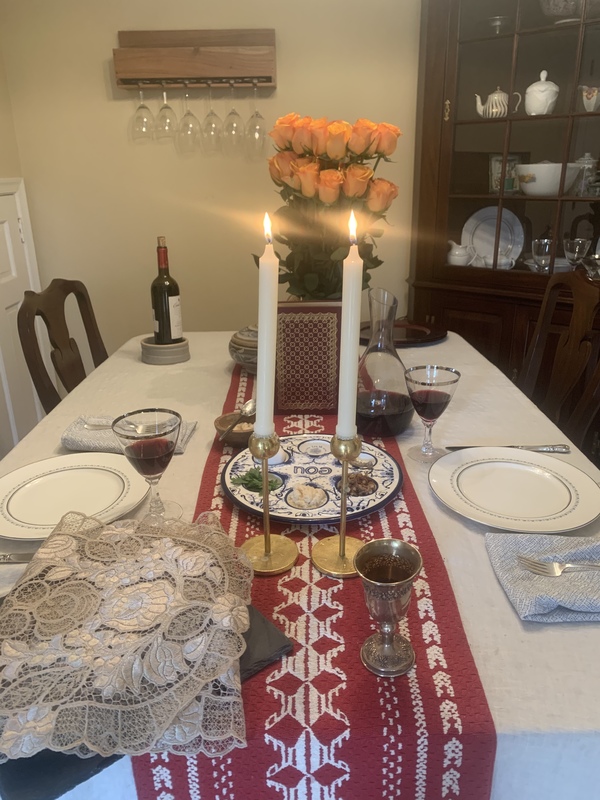 two lite candles with two place settings for passover