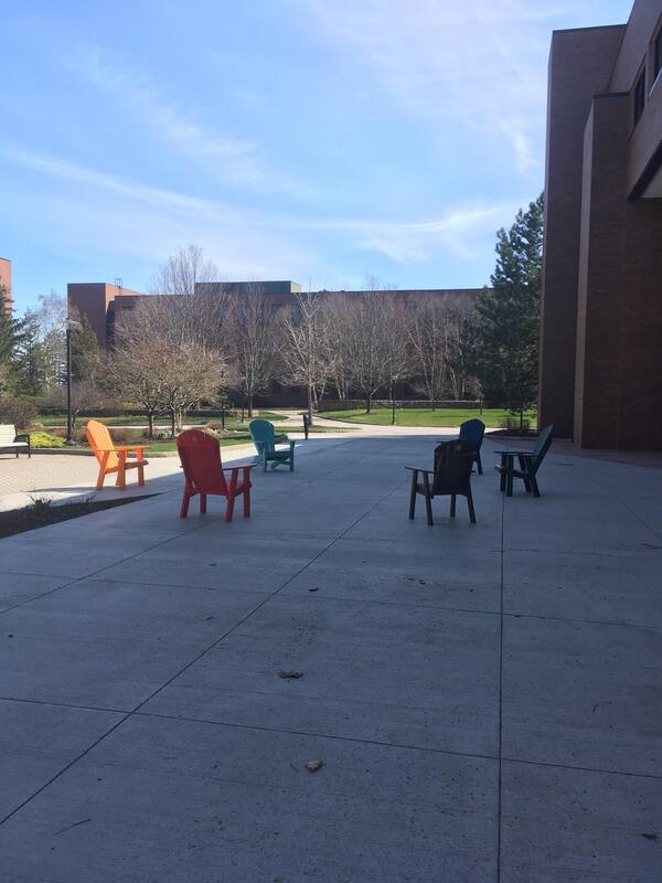 Six empty multicolored chairs. 