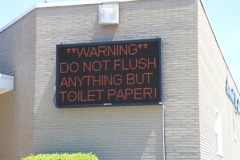 Digital Sign reading "Warning. Do not flush anything but toilet paper!"