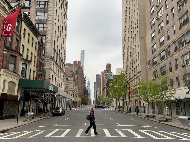 A person walking across a street in New York City. 