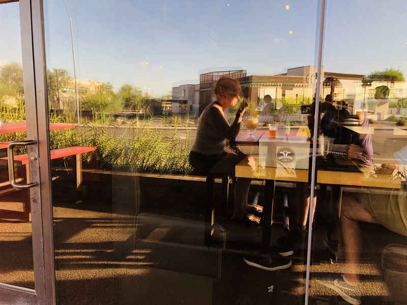 Photo of a woman drinking outside at a restaurant.