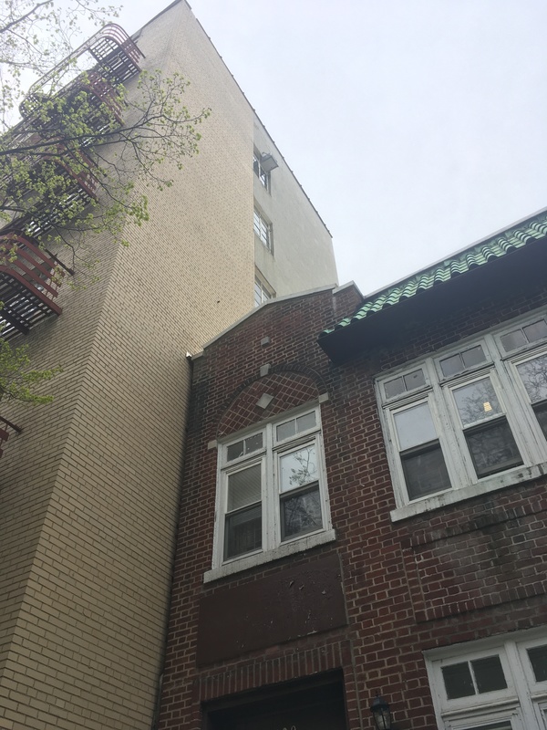 Two brick buildings, a red one on the right and a yellow one on the left. 