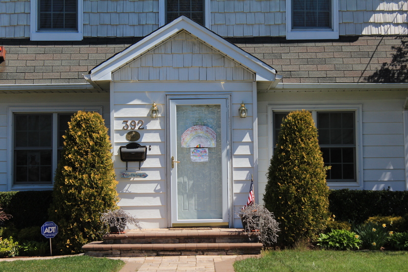 Residential house with a rainbow in the front screen door.  