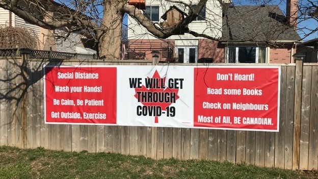 This is a picture of a sign printed in the colors of the Canadian flag which reads: "Social Distance, Wash Your Hands! Be Calm, Be Patient, Get Outside, Exercise... Don't Hoard! Read some Books, Check on Neighbors, Most of All, BE CANADIAN." Words are also printed over the maple leaf in the center which read "We Will Get Through COVID-19."