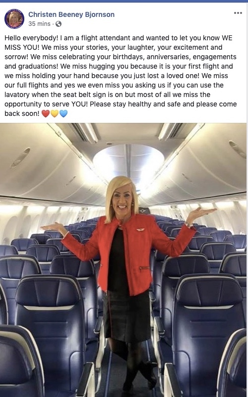 A flight attendant stands in front of empty plane seats. 