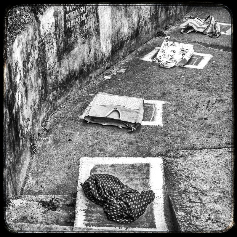 A queue of shopping bags outside of a store. 