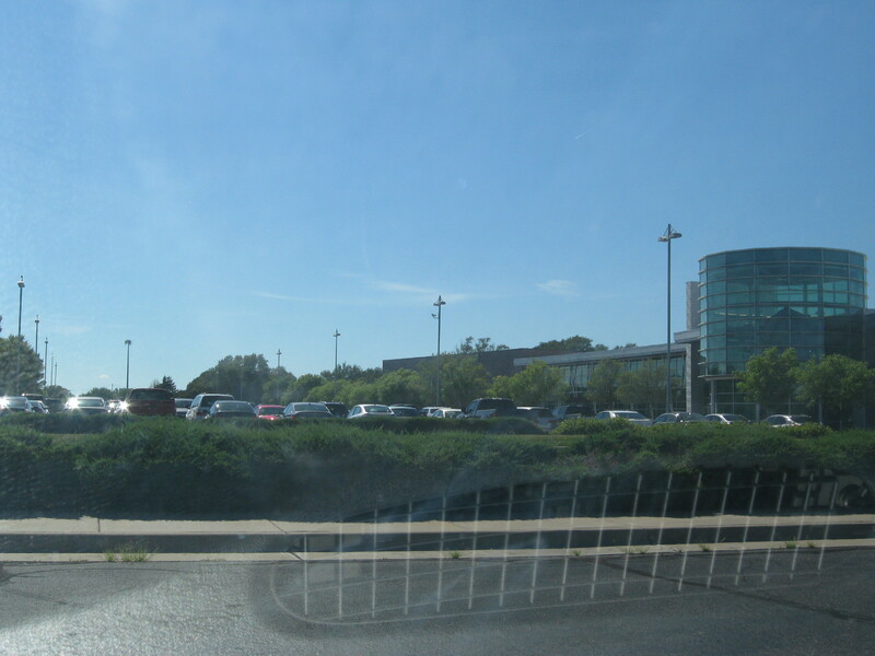 A photo of a building and a full parking lot.