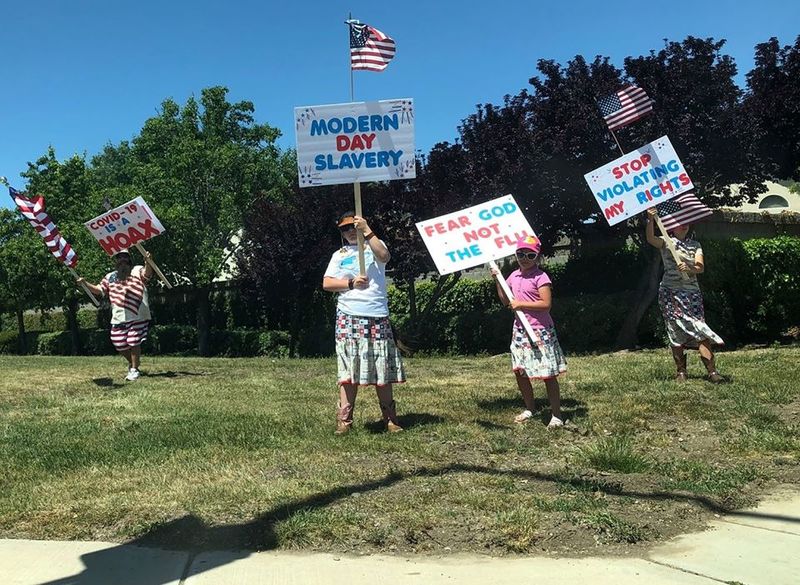 protestors holding signs against lock down