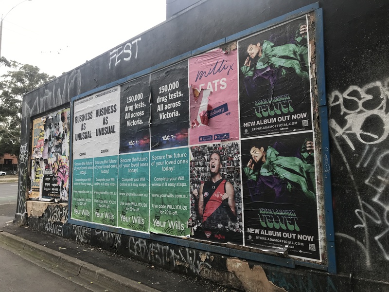 Two rows of posters for concerts on a black wall. 