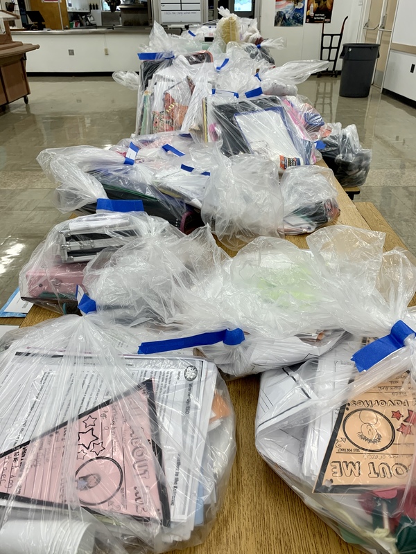 Plastic bags of things students left behind, laid out on cafeteria table.