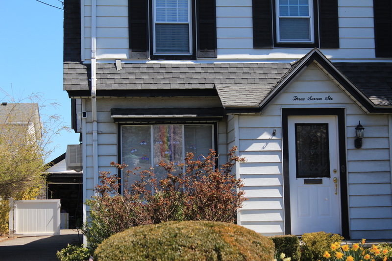 Residential house with a rainbow in the front window. 