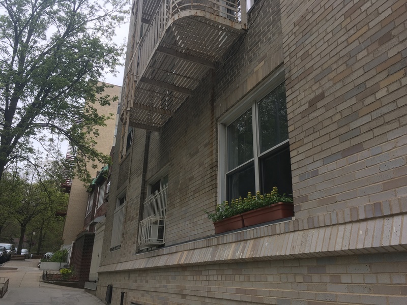 The front of brick buildings facing the sidewalk. 