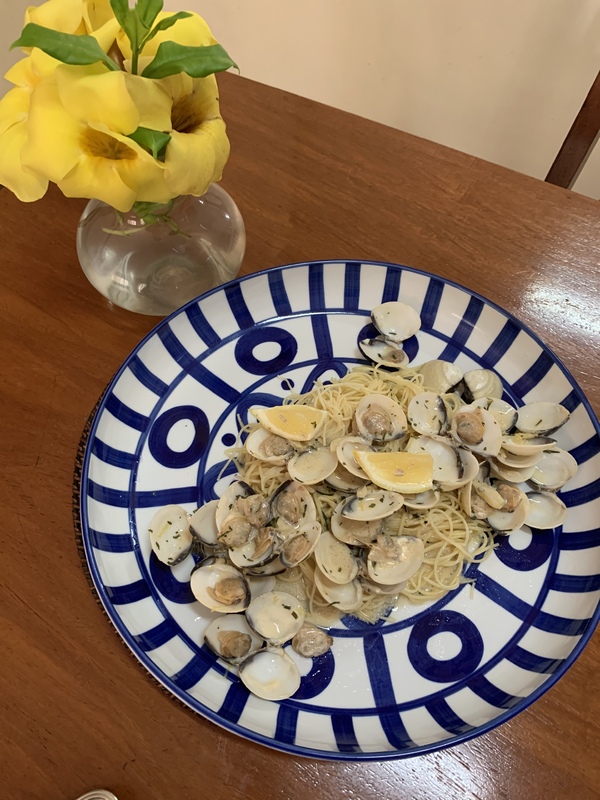 A plate of food and vase of flowers. 