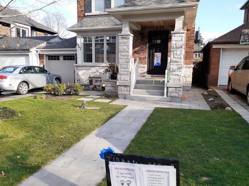 This is a picture of a home taken from the street, where a silver car can be seen in the driveway. 