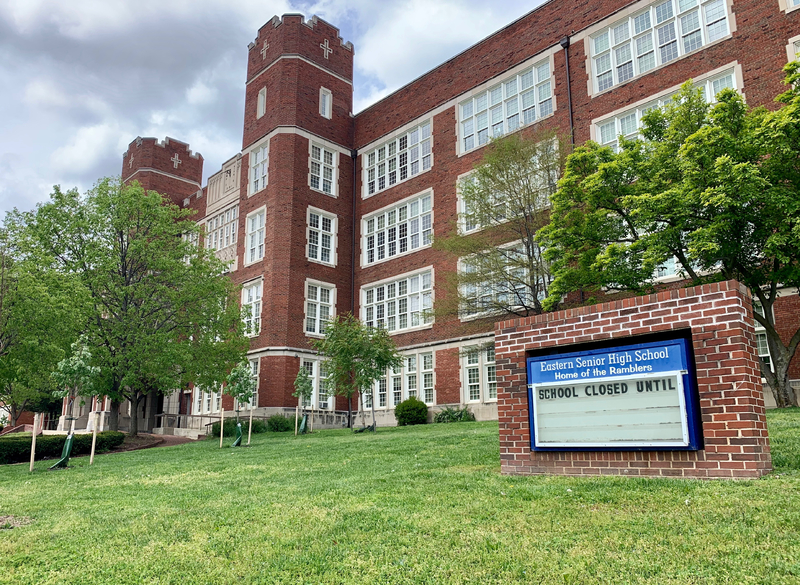 A sign outside of a highscool that reads "school closed until". 