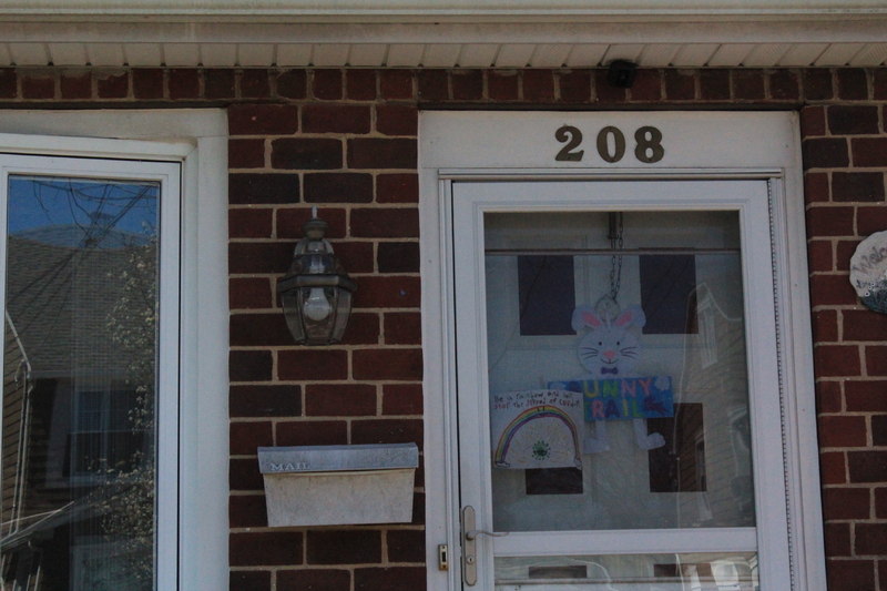 Residential house with a rainbow drawing on the front screen door.