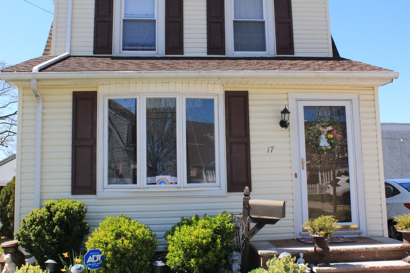 Residential house with a rainbow drawing in the front window. 