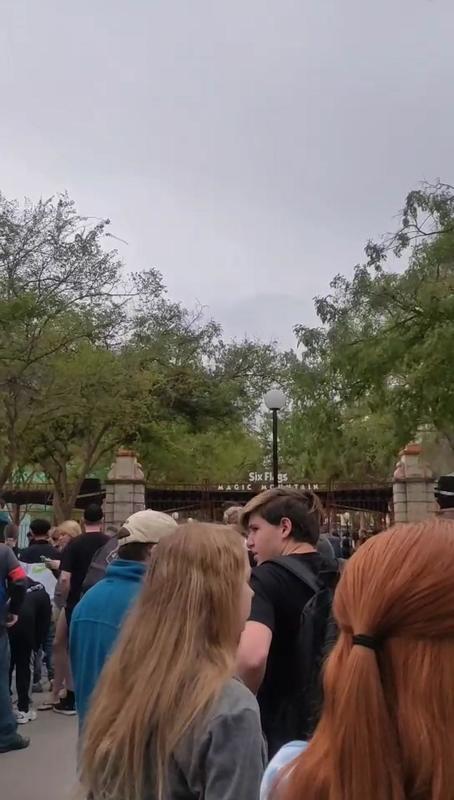 A crowd of people at an amusement park. 