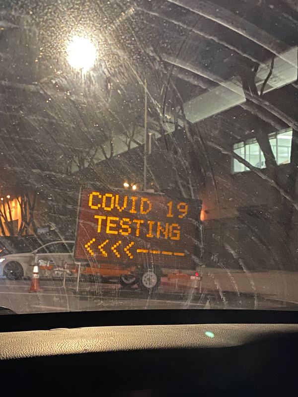 Electronic construction work sign with text, "COVID 19 TESTING" and an arrow pointing left. 