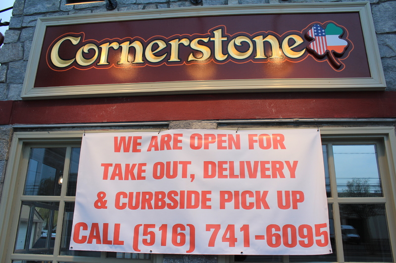 A restaurant called Cornerstone has a banner stating: "We are open for takeout, delivery, and curbside pickup" with their phone number underneath. 